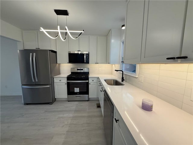 kitchen with white cabinetry, appliances with stainless steel finishes, and sink