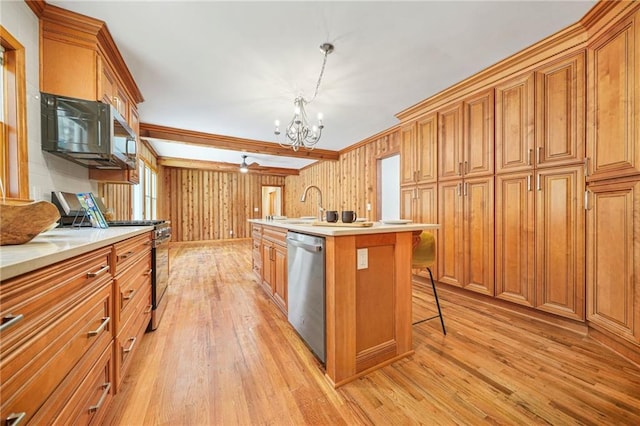 kitchen with a breakfast bar, a kitchen island with sink, hanging light fixtures, appliances with stainless steel finishes, and a chandelier