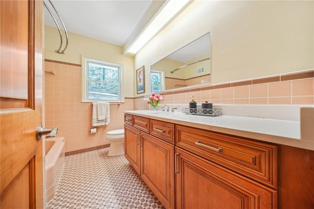 full bathroom with vanity, bathing tub / shower combination, tile walls, tile patterned flooring, and toilet