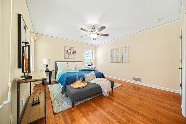 bedroom featuring hardwood / wood-style flooring, ceiling fan, and crown molding