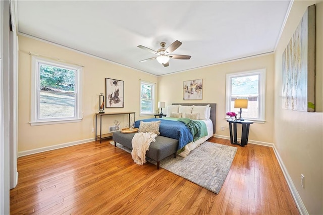 bedroom with ceiling fan, light wood-type flooring, and ornamental molding