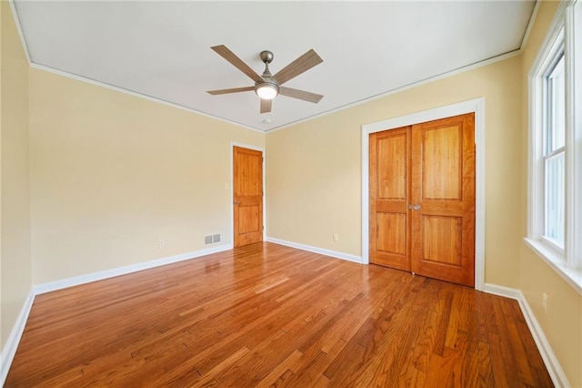 unfurnished bedroom with ceiling fan, hardwood / wood-style floors, and crown molding