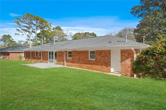 back of house with a patio area and a lawn