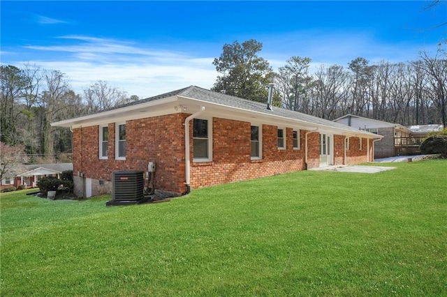 back of property featuring central air condition unit and a yard