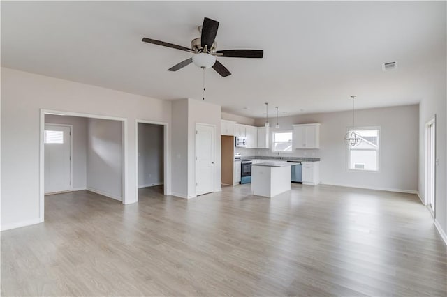 unfurnished living room with ceiling fan, light hardwood / wood-style floors, and sink