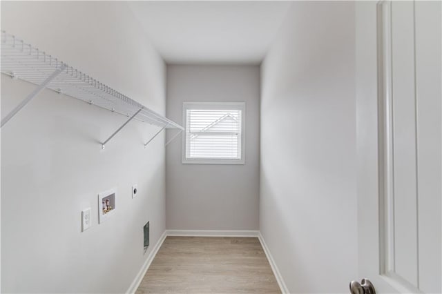 clothes washing area with hookup for a washing machine, light hardwood / wood-style flooring, and electric dryer hookup