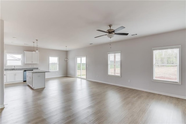 unfurnished living room featuring ceiling fan and light wood-type flooring