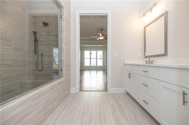 bathroom featuring vanity, ceiling fan, and tiled shower