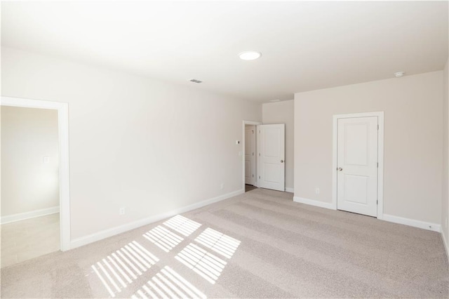 unfurnished room featuring light carpet