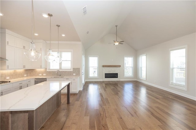 kitchen with sink, white cabinetry, a center island, appliances with stainless steel finishes, and pendant lighting