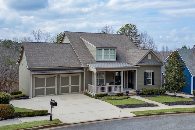 view of front of home featuring metal roof, a porch, an attached garage, driveway, and roof with shingles