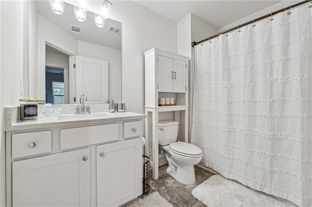 bathroom with curtained shower, visible vents, vanity, and toilet