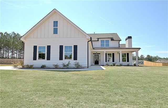 modern farmhouse style home featuring covered porch and a front lawn