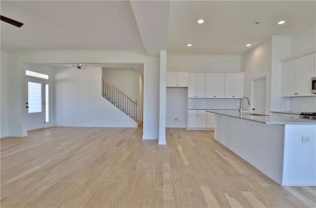 kitchen featuring light stone countertops, decorative backsplash, and white cabinetry