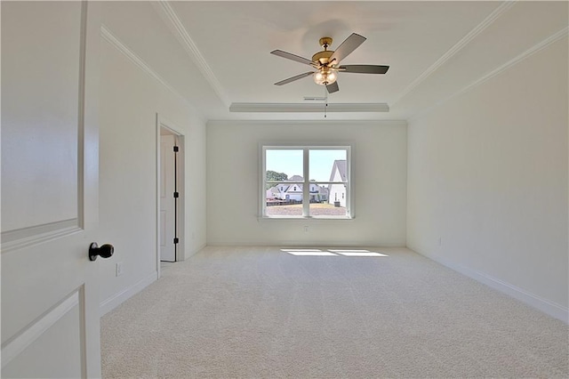 carpeted spare room featuring a tray ceiling, ceiling fan, and ornamental molding