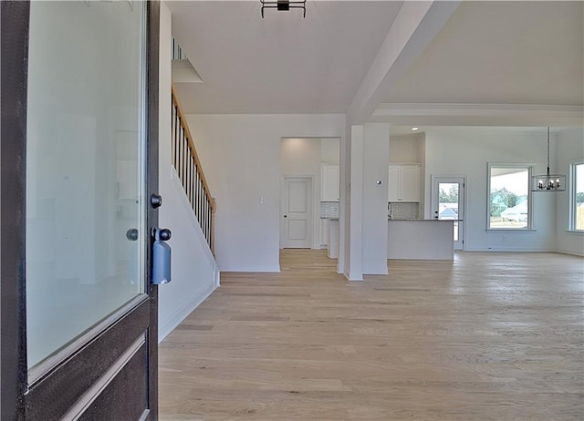 foyer entrance with a chandelier and light wood-type flooring