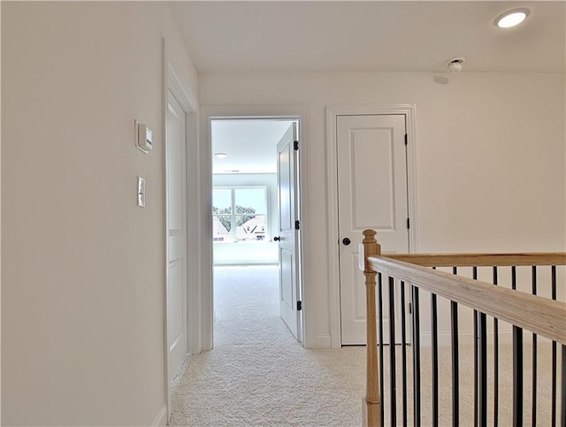 hallway featuring light colored carpet