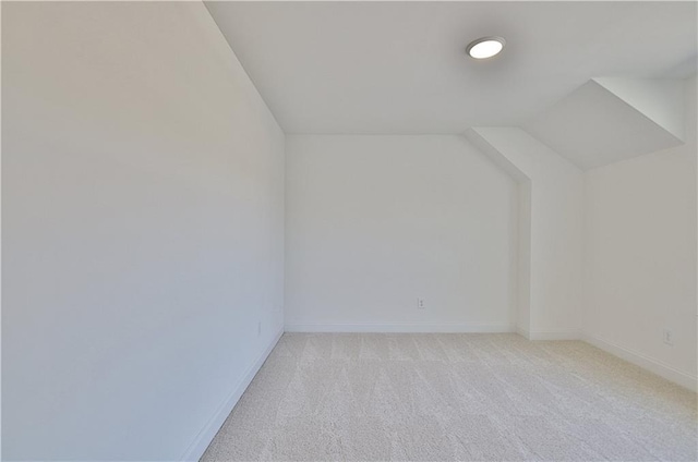 bonus room featuring light colored carpet and vaulted ceiling