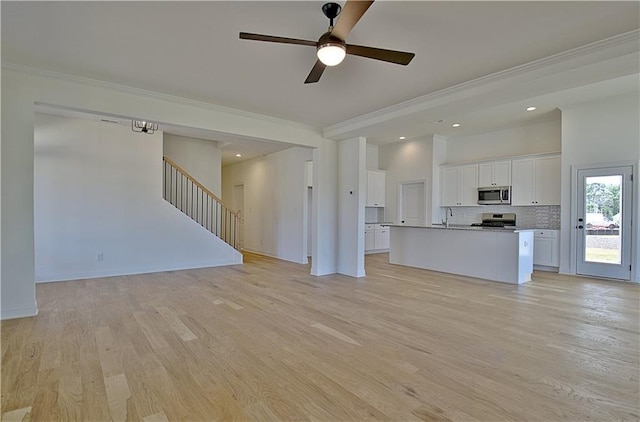 unfurnished living room with ceiling fan, sink, light hardwood / wood-style floors, and ornamental molding