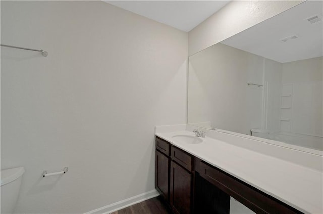 10814 Wheeler Trce, Hampton, GA 30228 - bathroom with toilet, vanity, wood finished floors, and baseboards