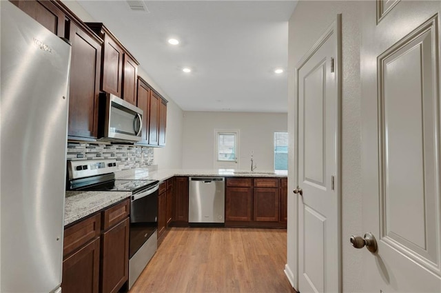 10814 Wheeler Trce, Hampton, GA 30228 - kitchen with stainless steel appliances, light wood-style floors, recessed lighting, light stone counters, and backsplash