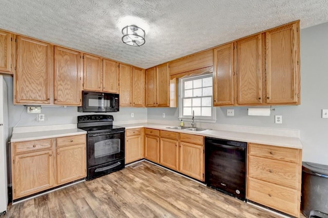 kitchen with light wood-type flooring, a textured ceiling, sink, and black appliances