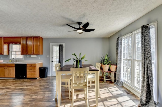 dining space featuring a textured ceiling, ceiling fan, light wood-type flooring, and sink