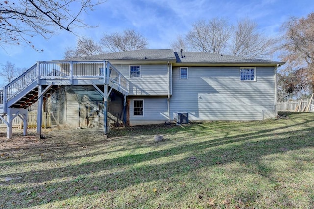 rear view of house with a lawn, cooling unit, and a wooden deck