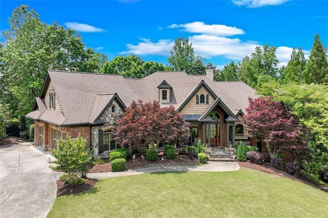 5623 Brendlynn Dr, Suwanee, GA 30024 - view of front facade featuring a front lawn, concrete driveway, stone siding, a chimney, and a garage