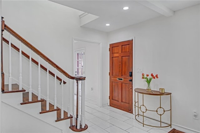 foyer featuring beam ceiling