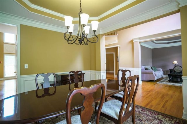 dining area featuring crown molding, wood-type flooring, and a chandelier