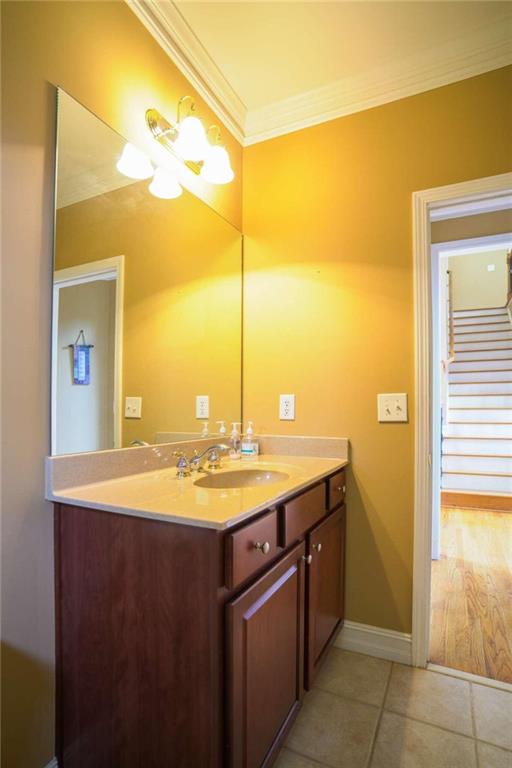 bathroom featuring vanity, ornamental molding, and tile patterned flooring