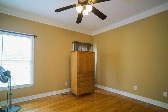 interior space featuring ornamental molding, light wood-type flooring, and ceiling fan