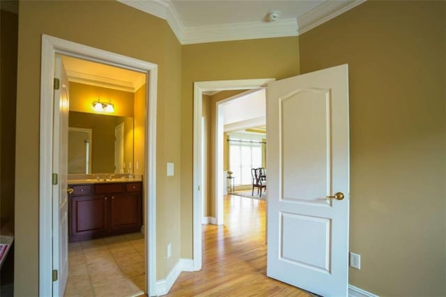 hallway with ornamental molding and light hardwood / wood-style flooring