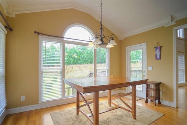 dining space featuring light hardwood / wood-style floors, lofted ceiling, a healthy amount of sunlight, and crown molding