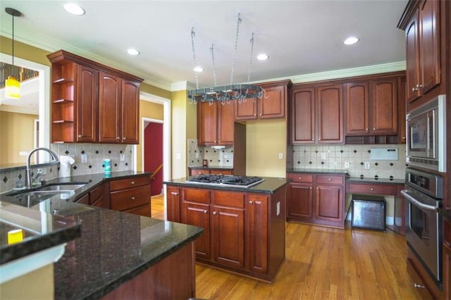 kitchen featuring stainless steel appliances, a notable chandelier, decorative light fixtures, light hardwood / wood-style floors, and tasteful backsplash