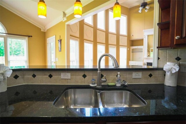 kitchen with decorative light fixtures, sink, and plenty of natural light