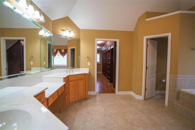 bathroom featuring vanity, tile patterned flooring, tiled bath, and vaulted ceiling