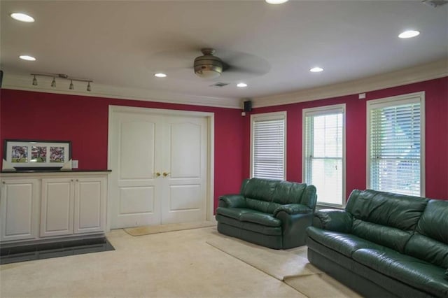 living room featuring crown molding, track lighting, light carpet, and ceiling fan