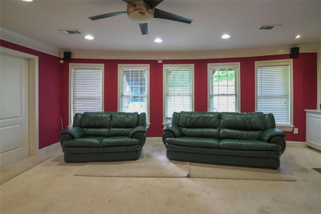 carpeted living room with ceiling fan and ornamental molding