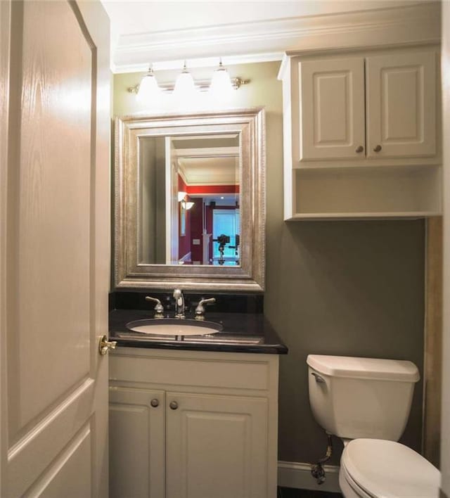 bathroom featuring vanity, crown molding, and toilet