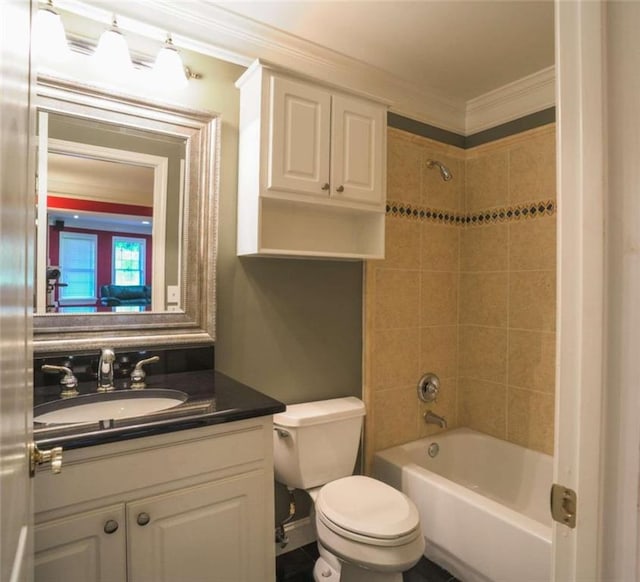 full bathroom featuring vanity, toilet, crown molding, and tiled shower / bath