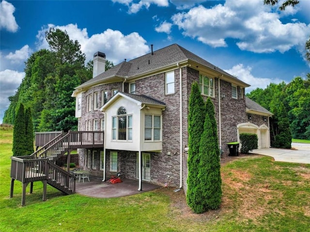 rear view of property with a patio, a yard, and a garage