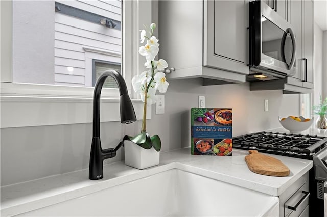 106 Hogue St, Atlanta, GA 30312 - kitchen with stainless steel microwave, light stone counters, and a sink