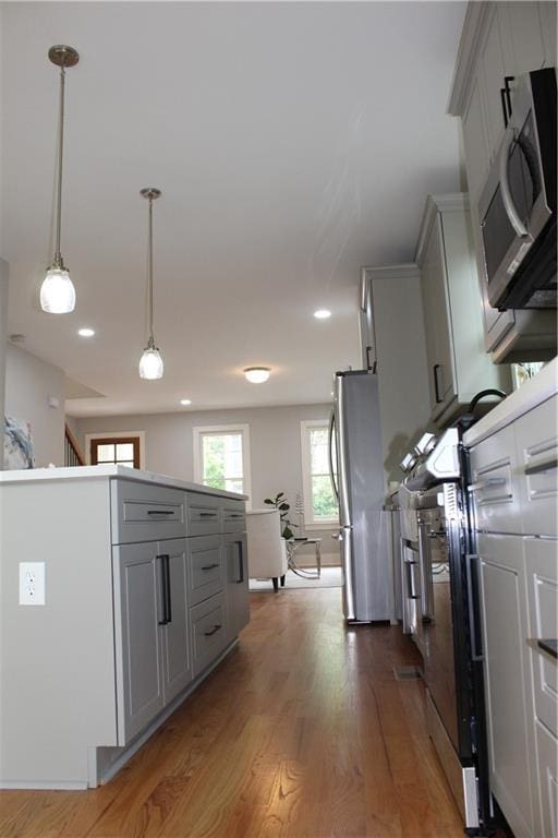 106 Hogue St, Atlanta, GA 30312 - kitchen featuring appliances with stainless steel finishes, gray cabinetry, wood finished floors, decorative light fixtures, and recessed lighting