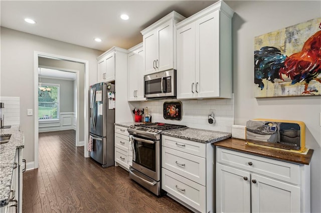 297 Cobblestone Trl, Dallas, GA 30132 - kitchen featuring appliances with stainless steel finishes, dark wood-style floors, backsplash, white cabinetry, and light stone counters