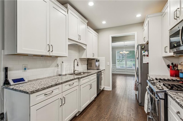 297 Cobblestone Trl, Dallas, GA 30132 - kitchen with appliances with stainless steel finishes, dark wood-style floors, white cabinets, light stone counters, and a chandelier