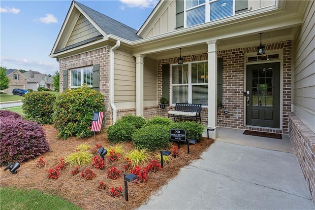 297 Cobblestone Trl, Dallas, GA 30132 - doorway to property with brick siding, covered porch, and board and batten siding