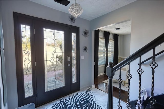 entryway featuring a notable chandelier and a textured ceiling