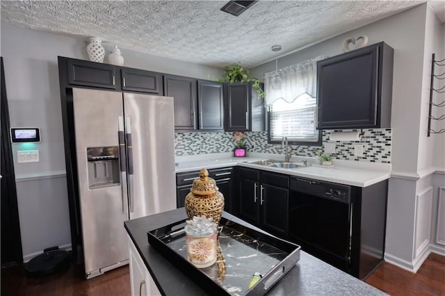 kitchen featuring sink, decorative light fixtures, stainless steel fridge, black dishwasher, and backsplash